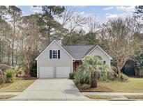 Charming home with a two-car garage, well-manicured lawn, and a vibrant red front door at 3518 Gatetree Rd, Johns Island, SC 29455