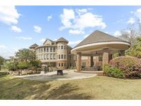 Stunning backyard with covered patio, outdoor fire pit, and meticulously manicured landscaping creating a luxurious outdoor space at 4202 Links Ct, North Charleston, SC 29420