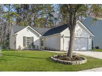 Charming single-story home features a well-manicured lawn and a classic white facade at 5080 Timicuan Way, Summerville, SC 29485