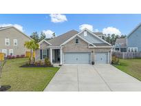 Charming brick home featuring a well-manicured lawn and a two-car garage at 532 Fern Tree Dr, Summerville, SC 29486