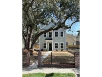 Charming two-story home with new paint, black trim windows, black fence and a beautiful mature tree at 651 Magnolia Rd, Charleston, SC 29407