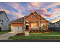 Charming one-story home with a well-manicured lawn and a cozy front porch with rocking chairs at 729 Quintan St, Summerville, SC 29486