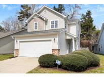 Charming two-story home features a garage and a welcoming front yard with lush greenery at 104 Chemistry Cir, Ladson, SC 29456