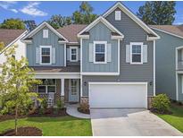 Charming two-story home with blue and gray siding, white trim, well-manicured lawn, and attached two-car garage at 109 Loon Dr, Summerville, SC 29483