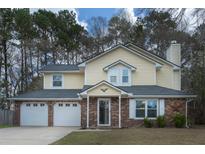Charming two-story home with yellow siding, brick accents, and a well-maintained front yard at 124 Knightsbridge Dr, North Charleston, SC 29418
