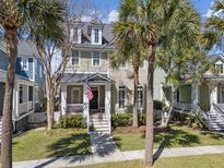 Charming two-story home with a welcoming front porch and beautiful landscaping, including palm trees at 150 Etiwan Park St, Charleston, SC 29492
