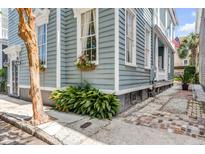 Charming home showcasing flower boxes, lush plants and brick sidewalk at 157 Tradd St, Charleston, SC 29401