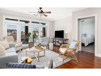Bright living room features a ceiling fan, many windows, hardwood floors, and a comfortable seating arrangement at 21 George St # 206, Charleston, SC 29401
