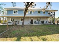 Two-story home featuring pale-blue wood planking, covered patio and porch, and a well-manicured front lawn at 2101 Guerins Bridge Rd, Wando, SC 29492
