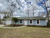 Charming single-story home featuring a white front door, light blue siding, and an attached one-car garage at 211 Amy Dr, Goose Creek, SC 29445