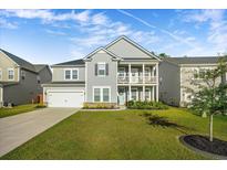Charming two-story home featuring a landscaped yard, two car garage, and a cozy front porch and balcony at 242 Bering Ln, Summerville, SC 29486
