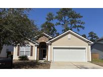Charming single-Gathering home with a manicured lawn, attached garage, and a welcoming front entrance at 2598 Spivey Ct, North Charleston, SC 29406
