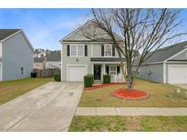 Charming two-story home with a well-manicured lawn, inviting front porch and attached garage at 326 Bradley Bend Dr, Moncks Corner, SC 29461