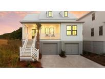 Charming two-story home with a white exterior, porch, and two-car garage at 377 Blowing Fresh Dr, Charleston, SC 29492