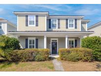 Inviting two-story home featuring a charming front porch and well-manicured landscaping at 4237 William E Murray Blvd, Charleston, SC 29414