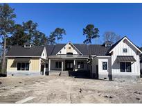 Charming new construction home featuring a metal roof and light yellow and white siding at Lot 20 Bulow Landing Rd, Hollywood, SC 29470