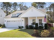 Charming single-Gathering home featuring a well-manicured lawn, inviting porch, and attached two-car garage at 1403 Thin Pine Dr, Johns Island, SC 29455
