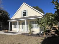 Charming single-Gathering home featuring light yellow siding, light green shutters, and a well-maintained front yard at 1412 Sandstone Pl, Charleston, SC 29492