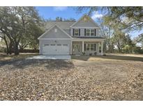 Charming two-story home with a manicured lawn, attached garage and inviting front porch at 1459 Brownswood Rd, Johns Island, SC 29455