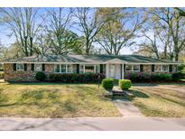 Charming brick home with a manicured lawn, flowering shrubs, and classic black shutters at 1929 Westminster Rd, Charleston, SC 29407