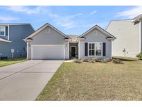 Charming single-story home featuring a manicured lawn and a convenient attached two-car garage at 1941 Zonny Moss Dr, Johns Island, SC 29455
