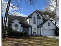 Charming two-story home featuring white siding, a dark roof, attached garage and well-manicured landscaping at 203 Candleberry Cir, Goose Creek, SC 29445