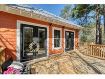 A cozy outdoor deck features double doors, natural wood, and a pleasant view, perfect for relaxing or entertaining at 247 Lotz Dr, Summerville, SC 29483