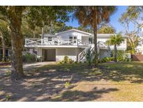 Charming two-story home boasts a wrap-around porch, lush landscaping, and a two-car garage at 29 27Th Ave, Isle of Palms, SC 29451