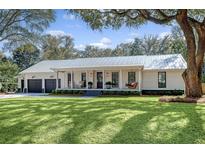 Charming single-story home with a metal roof, inviting front porch with a swing, and a well-manicured lawn at 299 Bampfield Dr, Mount Pleasant, SC 29464
