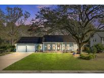 Charming single-story home featuring solar panels, a well-manicured lawn, and a welcoming front porch at 32 Monte Sano Dr, Hanahan, SC 29410