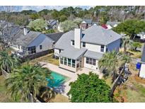 Stunning aerial view of backyard with pool and enclosed sunroom addition on this well-maintained two-story home at 3274 Heathland Way, Mount Pleasant, SC 29466