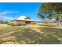 A charming single-story brick home on a large lot with a metal roof and lush, green landscaping at 732 Lindhaven Dr, Pineville, SC 29468