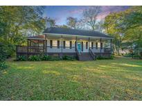 Charming single-story home with a inviting front porch and a well-maintained lawn at 749 Sprague St, Charleston, SC 29412