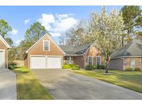 Charming brick home with two-car garage, manicured lawn, and blooming tree in a well-kept neighborhood at 779 Hamlet Cir, Goose Creek, SC 29445