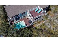 Stunning aerial view of a two-story home featuring a private pool, multiple decks, and lush landscaping at 8 Fairway Oaks Ln, Isle of Palms, SC 29451