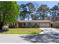 Charming brick home with a well-manicured lawn and mature trees at 8341 Delhi Rd, North Charleston, SC 29406