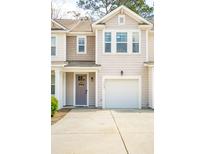 Charming townhome showcases a lovely facade with a single-car garage and well-manicured lawn at 9402 Sweep Dr, Summerville, SC 29485