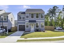 Charming two-story home with light blue siding, a gray garage door, and a well-manicured green lawn at 1032 Berry Patch Cir, Summerville, SC 29485