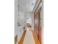 Inviting entryway featuring hardwood floors, custom built-ins, and a stylish light fixture at 106 Queen St # B, Charleston, SC 29401