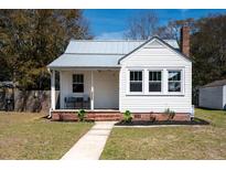 Charming home with a metal roof, cozy front porch, and manicured landscaping at 1134 North Blvd, North Charleston, SC 29405