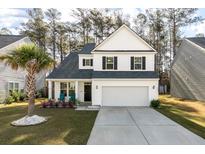 Charming two-story home features a well-manicured lawn, a two-car garage, and lovely landscaping at 133 Caleb Ct, Ladson, SC 29456