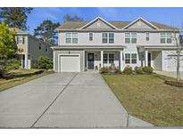 Inviting two-story home featuring neutral siding, well-manicured lawn and a convenient one-car garage at 145 Wild Holly Dr, Moncks Corner, SC 29461