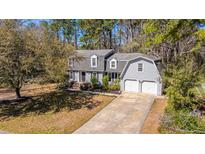 Charming two-story home with a well-manicured lawn, a two-car garage, and mature trees at 202 Hunt Club Dr, Summerville, SC 29485