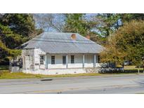 Charming single-story home featuring a covered front porch and a brick chimney, set on a tree-lined street at 2604 Highway 78, Dorchester, SC 29437