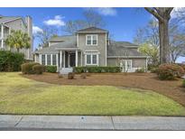 Charming home boasts inviting curb appeal with a manicured lawn and mature landscaping at 2606 Marsh Creek Dr, Charleston, SC 29414