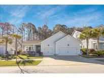 Charming two-story home with a manicured lawn, two-car garage, and light blue siding at 2620 Private Lefler Dr, Johns Island, SC 29455