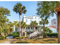 Stunning coastal home with multiple balconies, a welcoming front porch, and lush palm trees creating a tropical paradise at 3 Cross Ln, Isle of Palms, SC 29451
