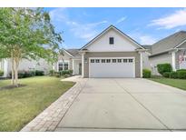 Charming single-story home with a well-manicured lawn, attached garage, and inviting curb appeal at 418 Eastern Isle Ave, Summerville, SC 29486