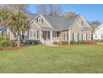 Charming two-story home featuring a landscaped front yard and inviting covered porch with white railing at 4218 Club Course Dr, North Charleston, SC 29420