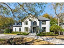 Stunning two-story white brick home with black trim, elegant arched entry, and manicured landscaping at 442 Channel Creek Ct, Mount Pleasant, SC 29464